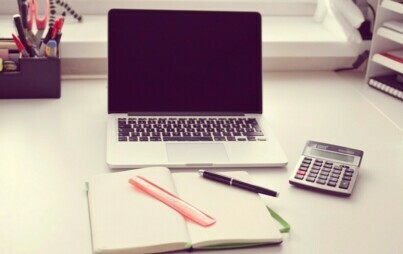 Lężący na biurku laptop, długopis i kalkulator 