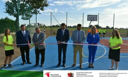 samorządowcy przecinający wstęgę podczas oficjalnego otwarcia boiska w Borównie 